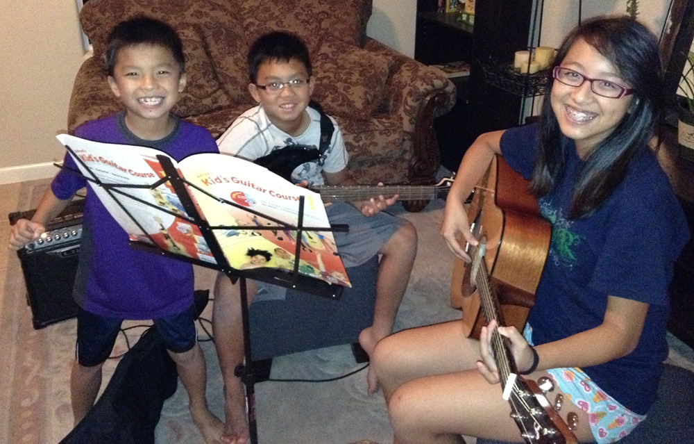 Some young students taking guitar lesson