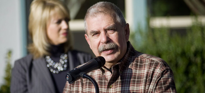 Juan Arambula speaking in front of a microphone at an event