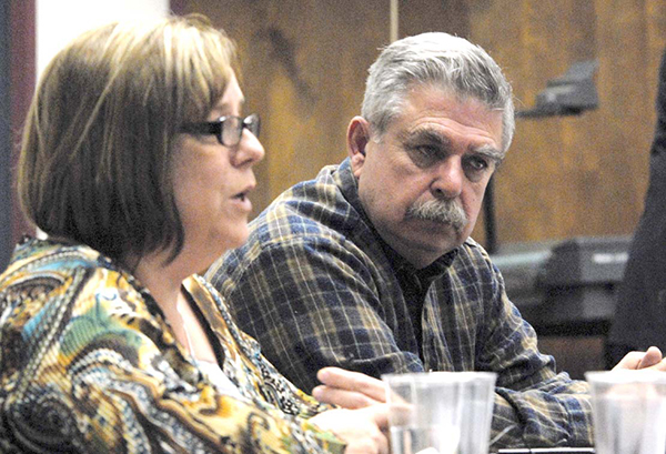 Juan Arambula sitting at a meeting alongside a women that is speaking