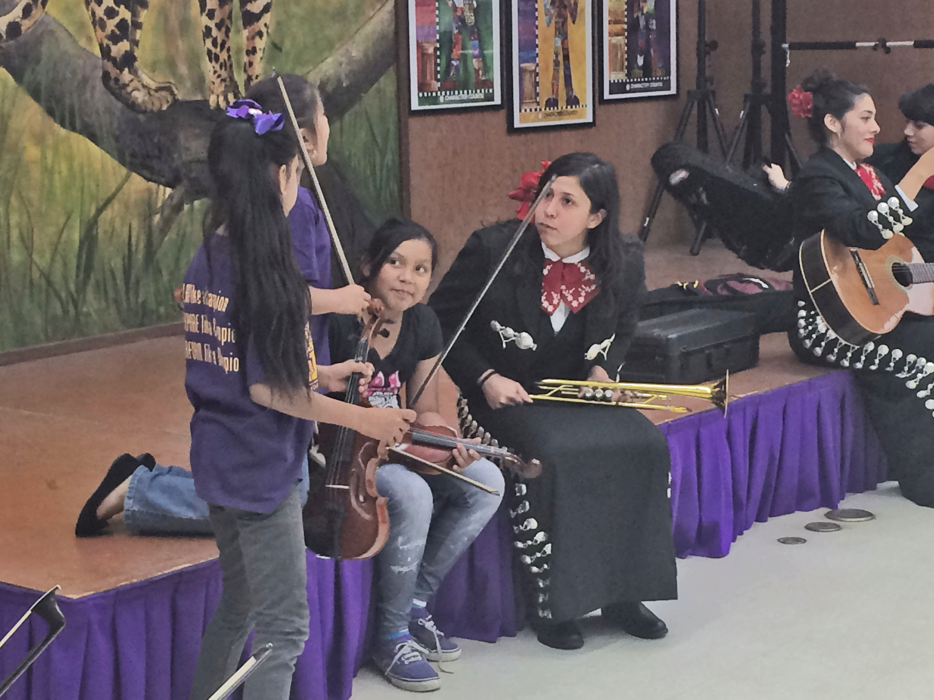 students speaking with mariachi trumpet player
