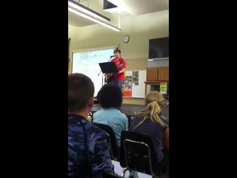 Student performing with guitar in front of other students