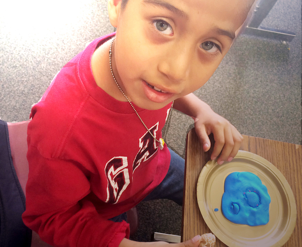 Student with clay art project